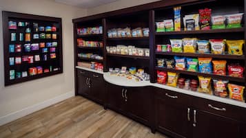 A snack bar with shelves stocked with various chips, crackers, and other snacks.
