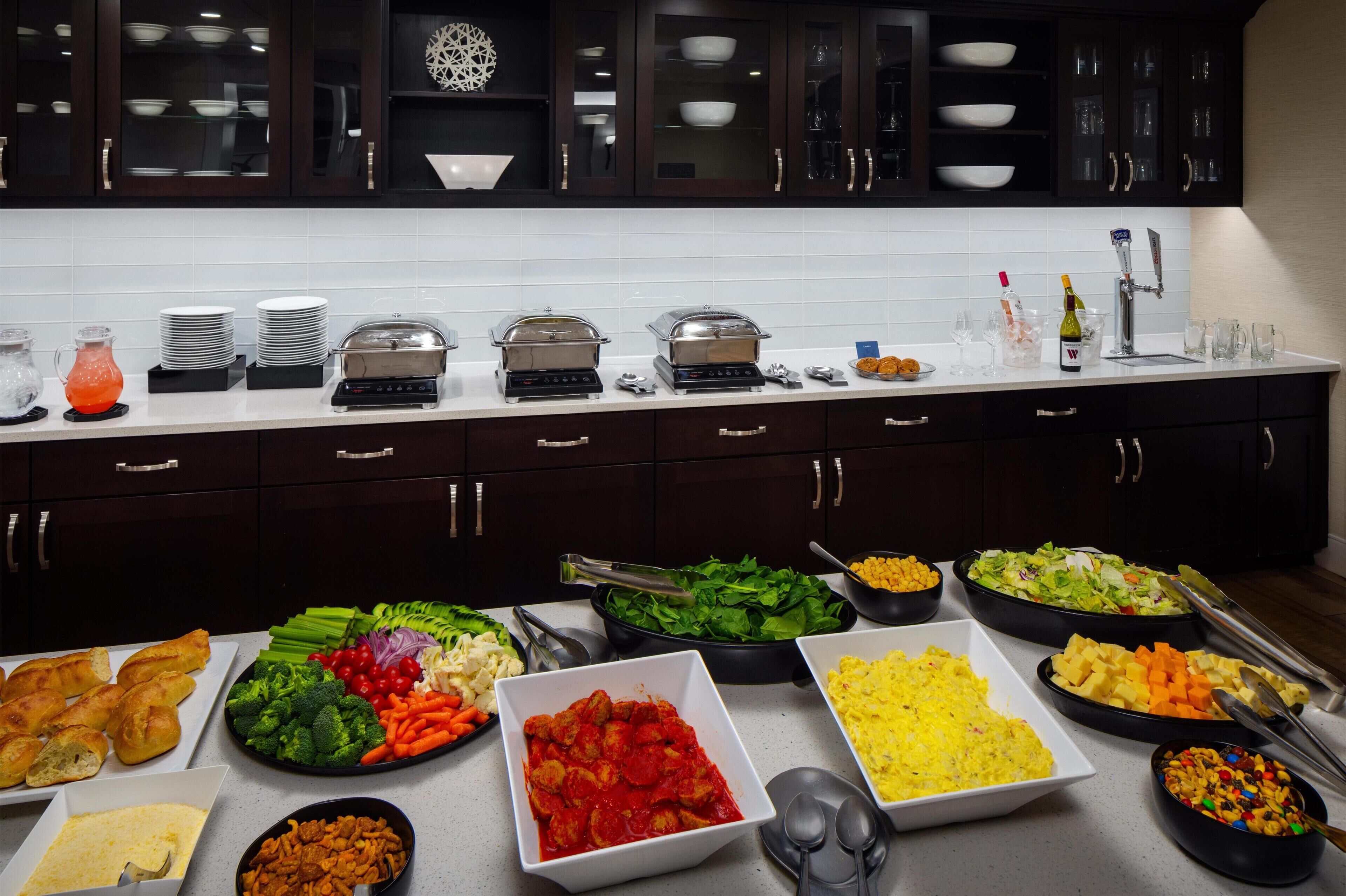 A buffet setup with various food items and kitchenware.