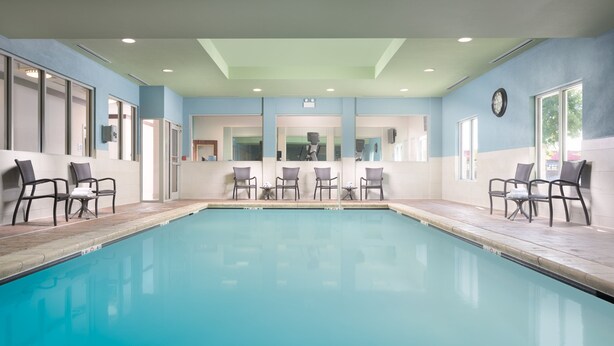 A pool area with chairs and a clock on the wall. - Holiday Inn Express Hotel & Suites Chattanooga Downtown by IHG (Chattanooga)