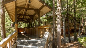 A wooden covered bridge with a wooden railing, surrounded by trees. - Mountain Retreat Resort (Arnold)