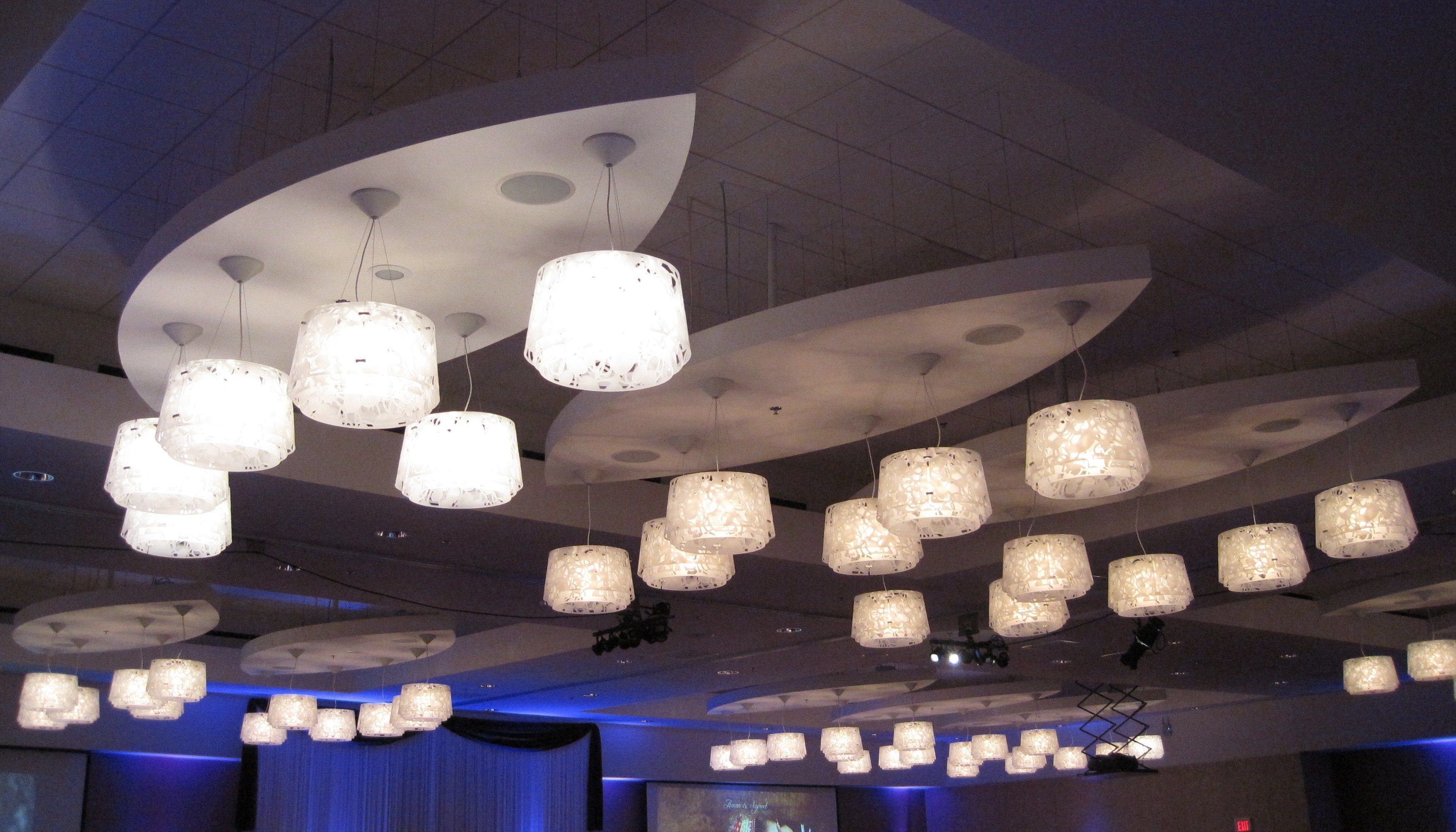 A ceiling with multiple hanging pendant lights and a curved architectural design.