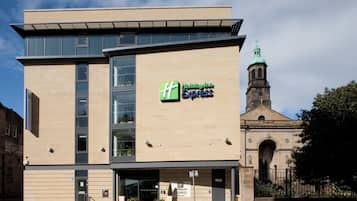 A Holiday Inn Express building with a modern design, large windows, and a visible entrance.