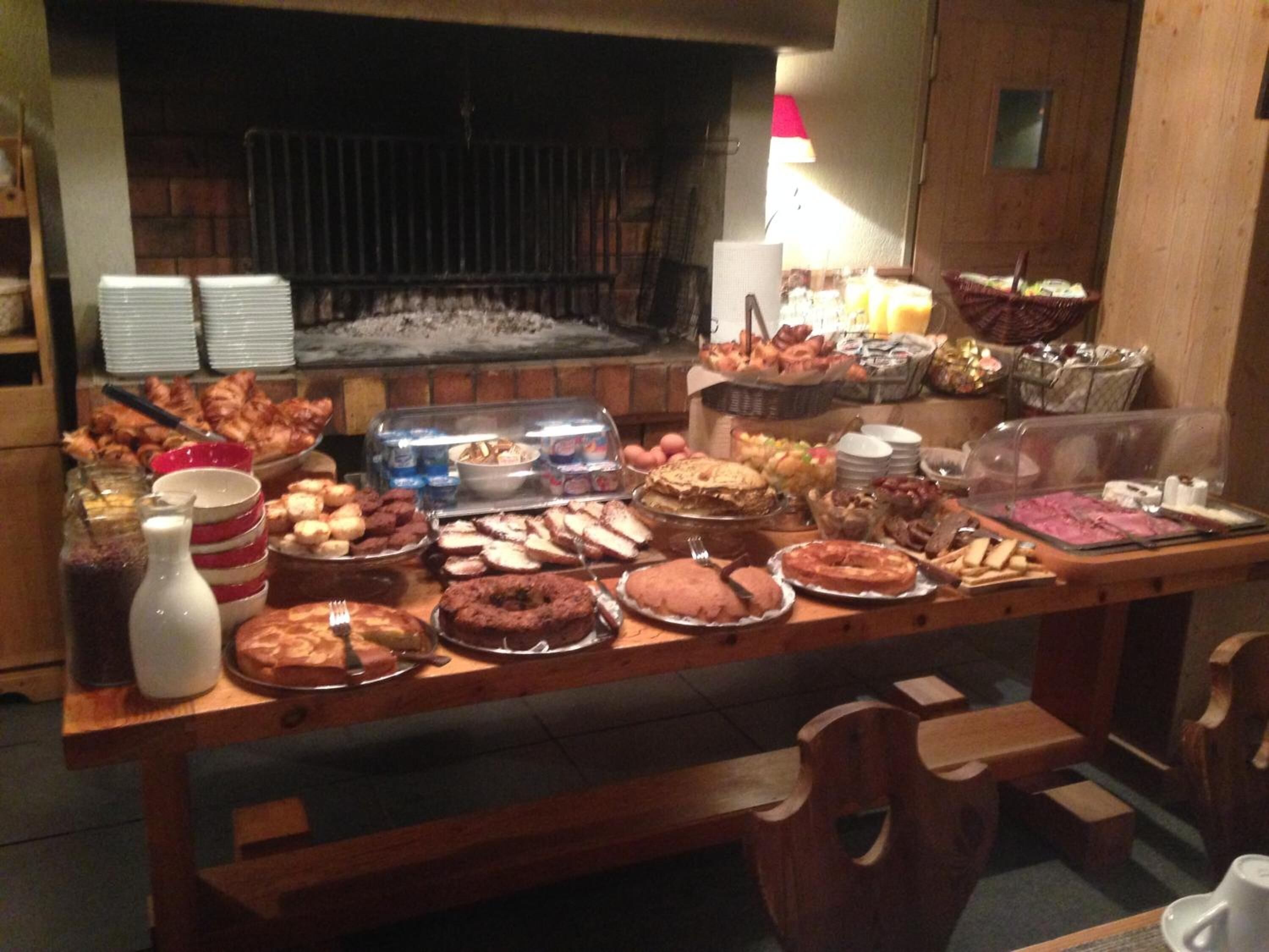 En buffet med forskellige retter og en pejs i baggrunden.