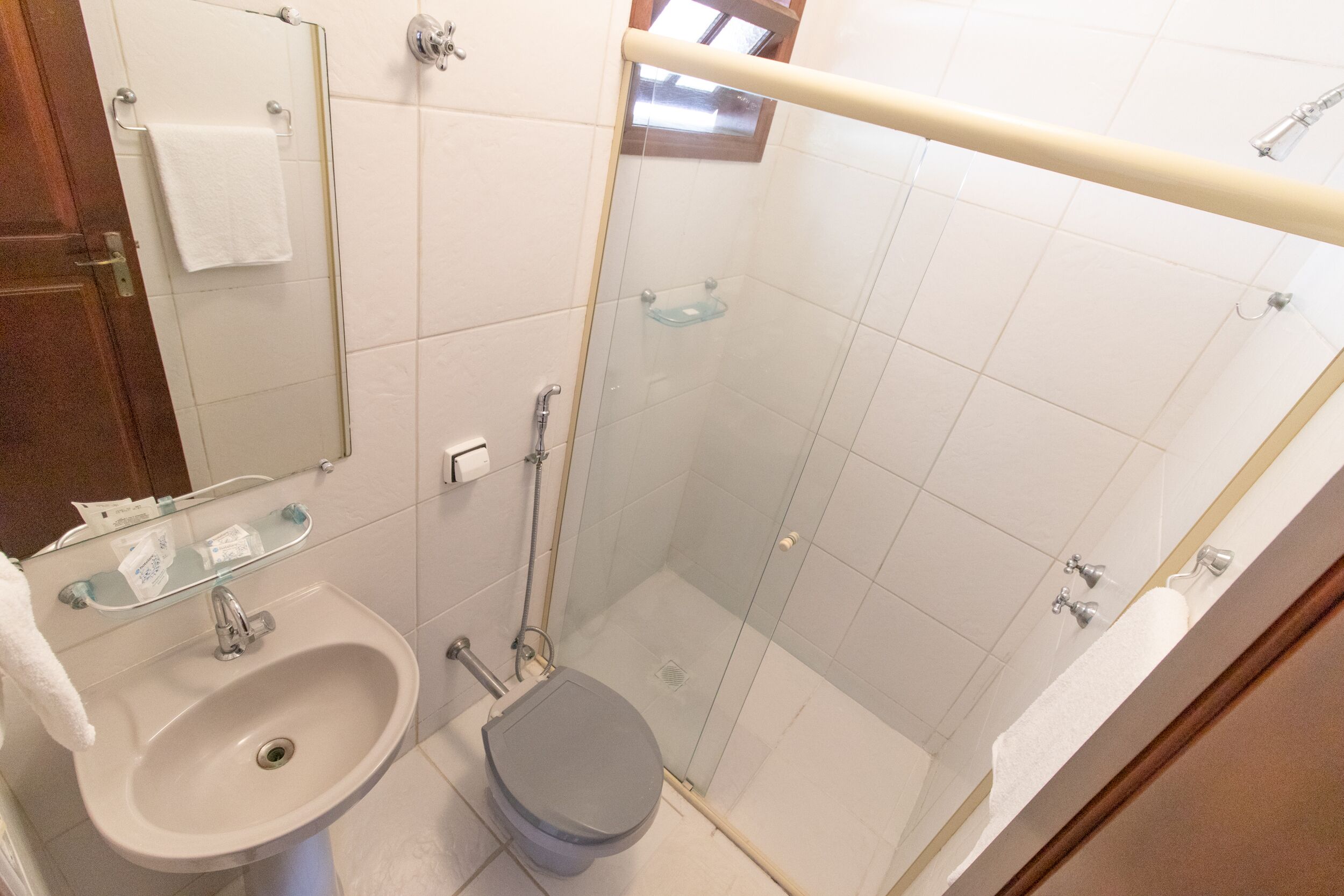Un baño con lavamanos, inodoro y cabina de ducha de vidrio.