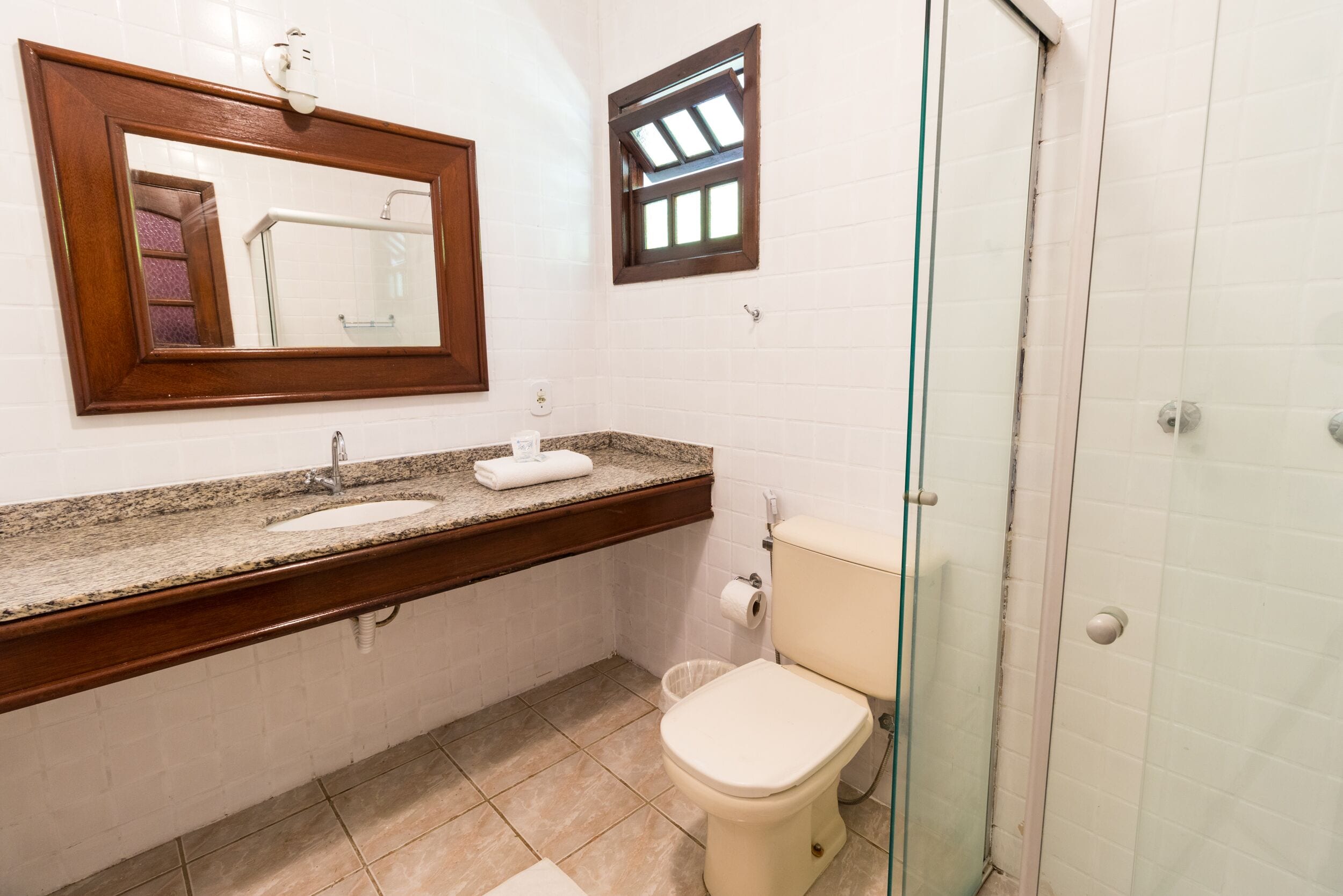 Un baño con lavamanos, espejo, inodoro y ducha.