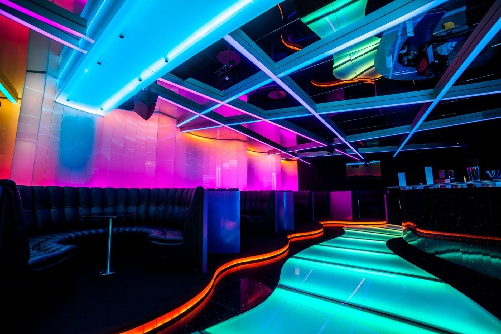 A modern lounge area with neon lighting and a curved seating arrangement.