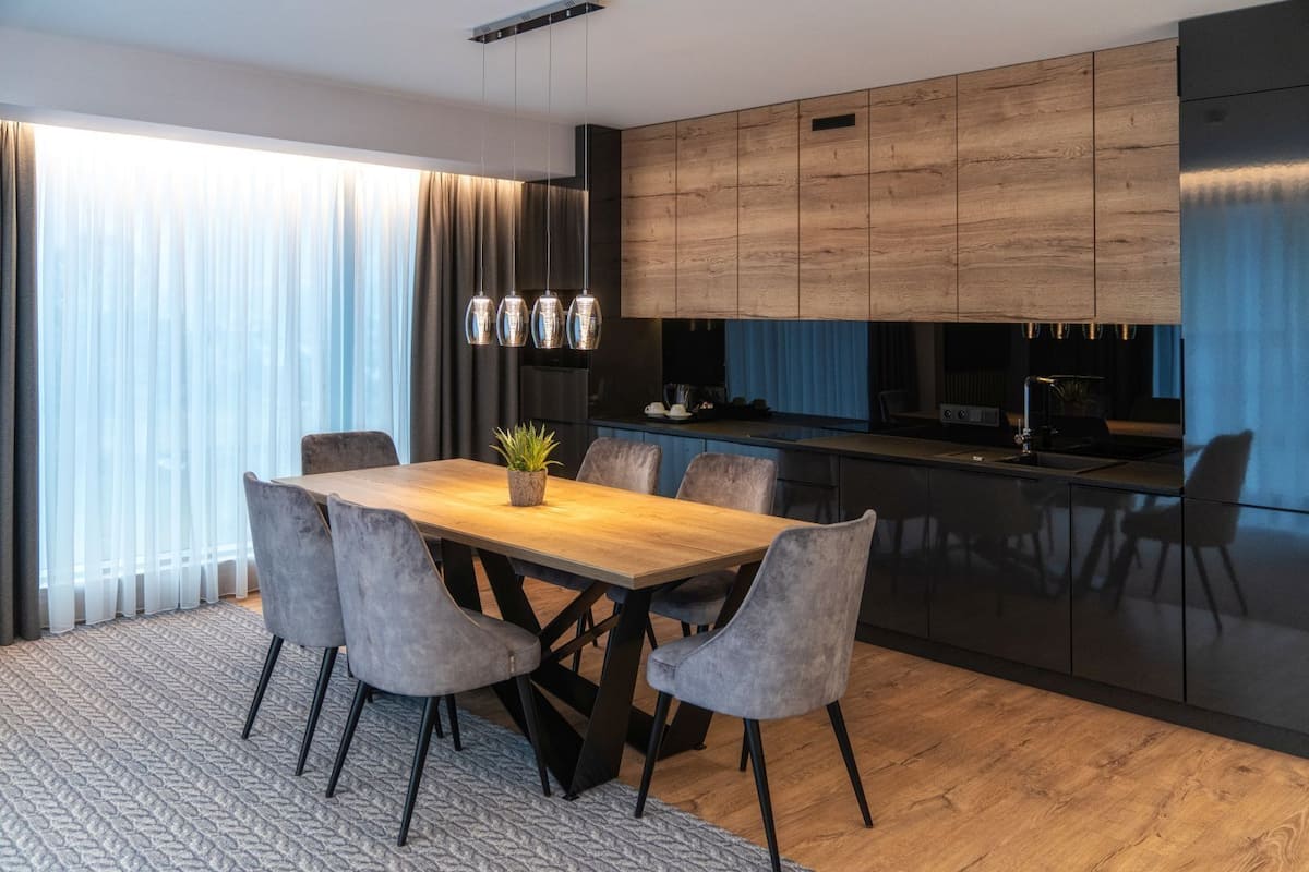 Una cocina moderna con armarios de madera, una isla central e iluminación colgante.