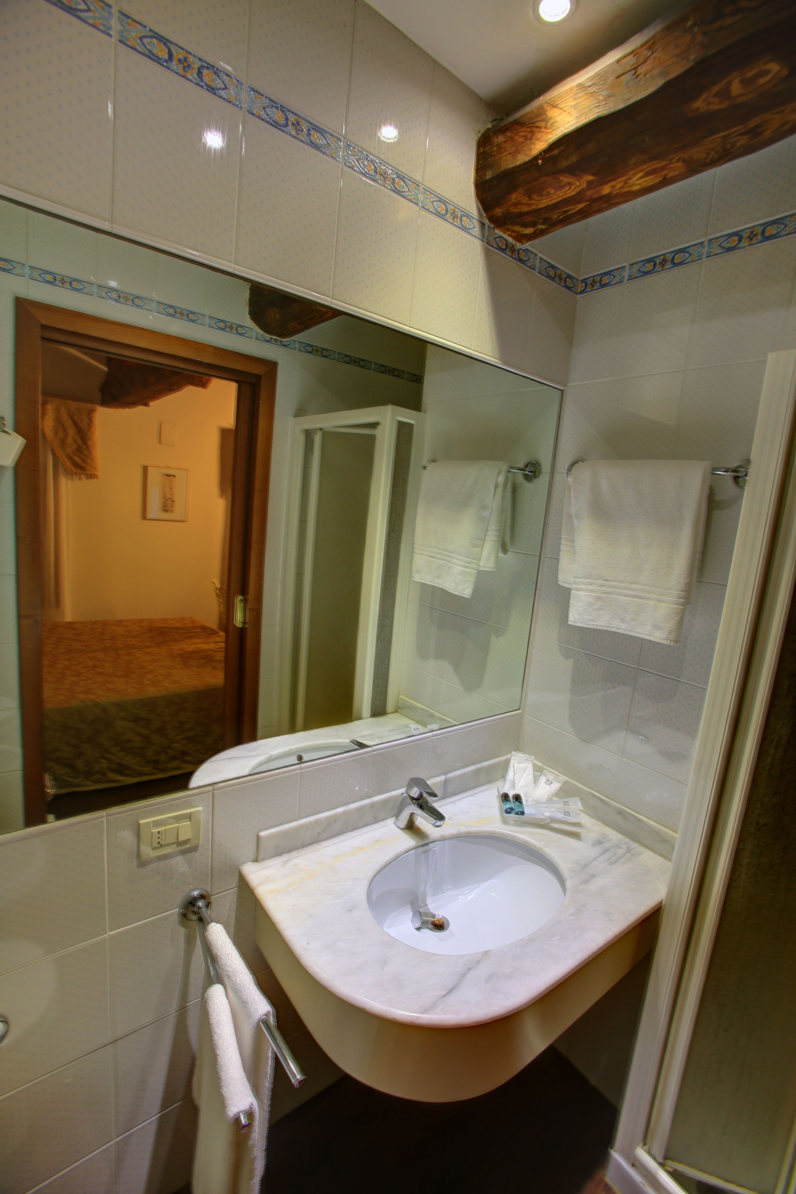 A bathroom with a sink, mirror, and towel rack.