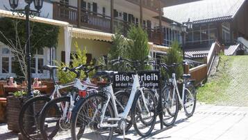 Una fila de bicicletas estacionadas frente a un edificio con un letrero que dice "Bike-Verleih an der Hohen Rezeption".