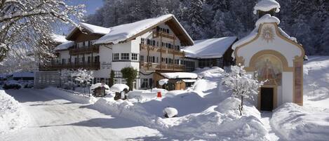 A snow-covered building with a balcony and a chapel.