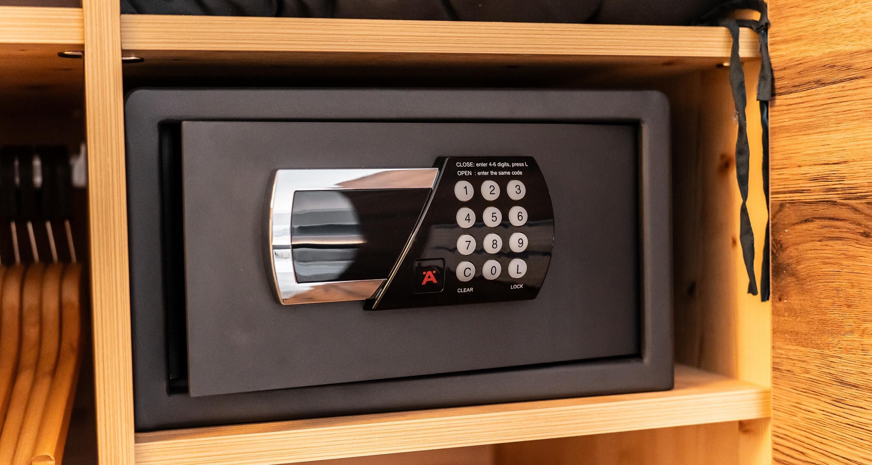 A black electronic device with a keypad and a lock button, housed in a wooden drawer.