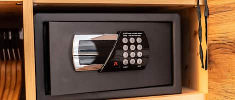 A black electronic device with a keypad and a lock button, housed in a wooden drawer.