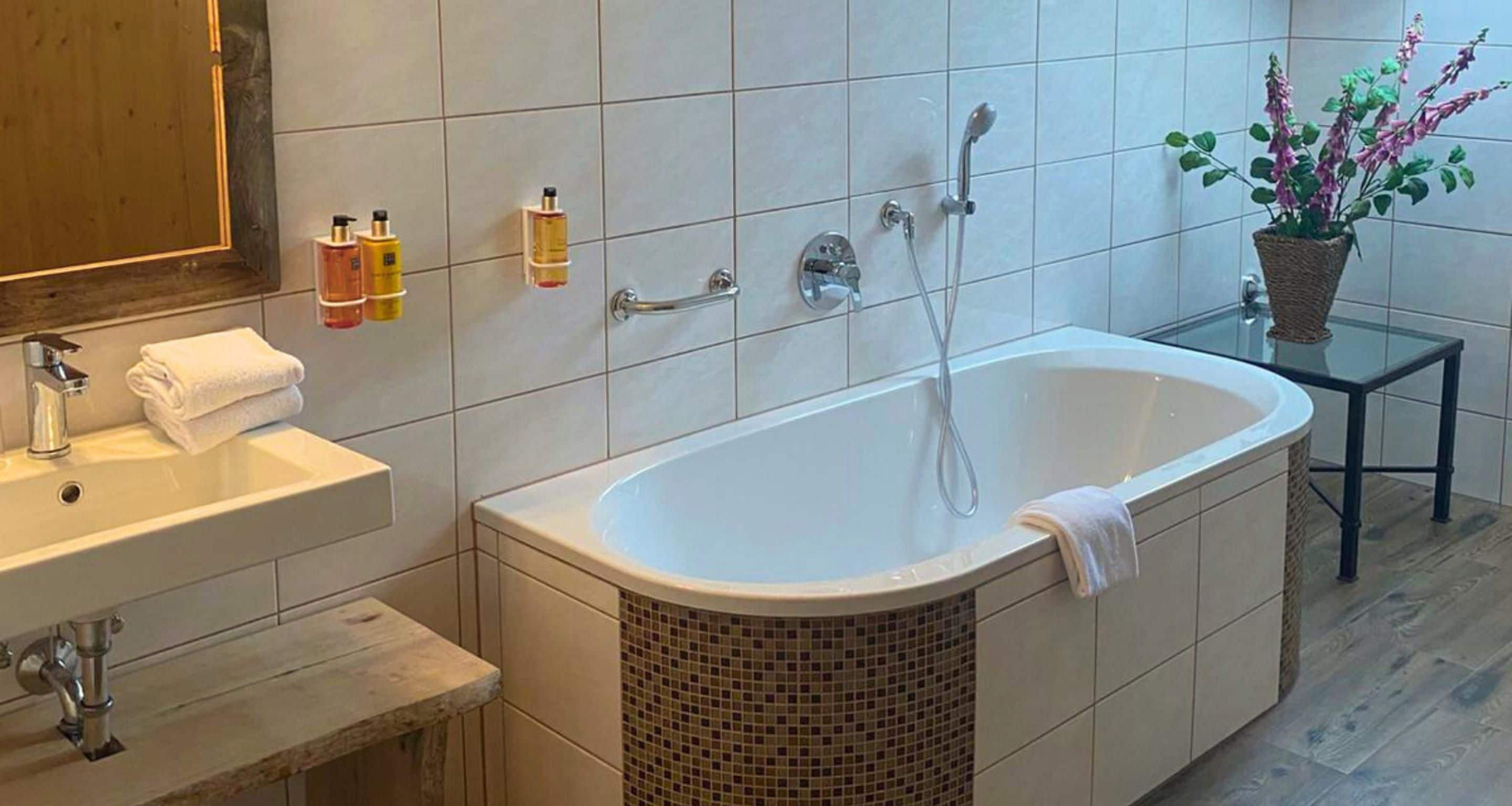 Een moderne badkamer met een vrijstaand bad, een wastafel en een spiegel.