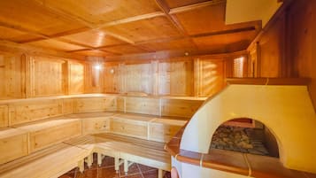 A sauna with wooden benches and a stone floor.