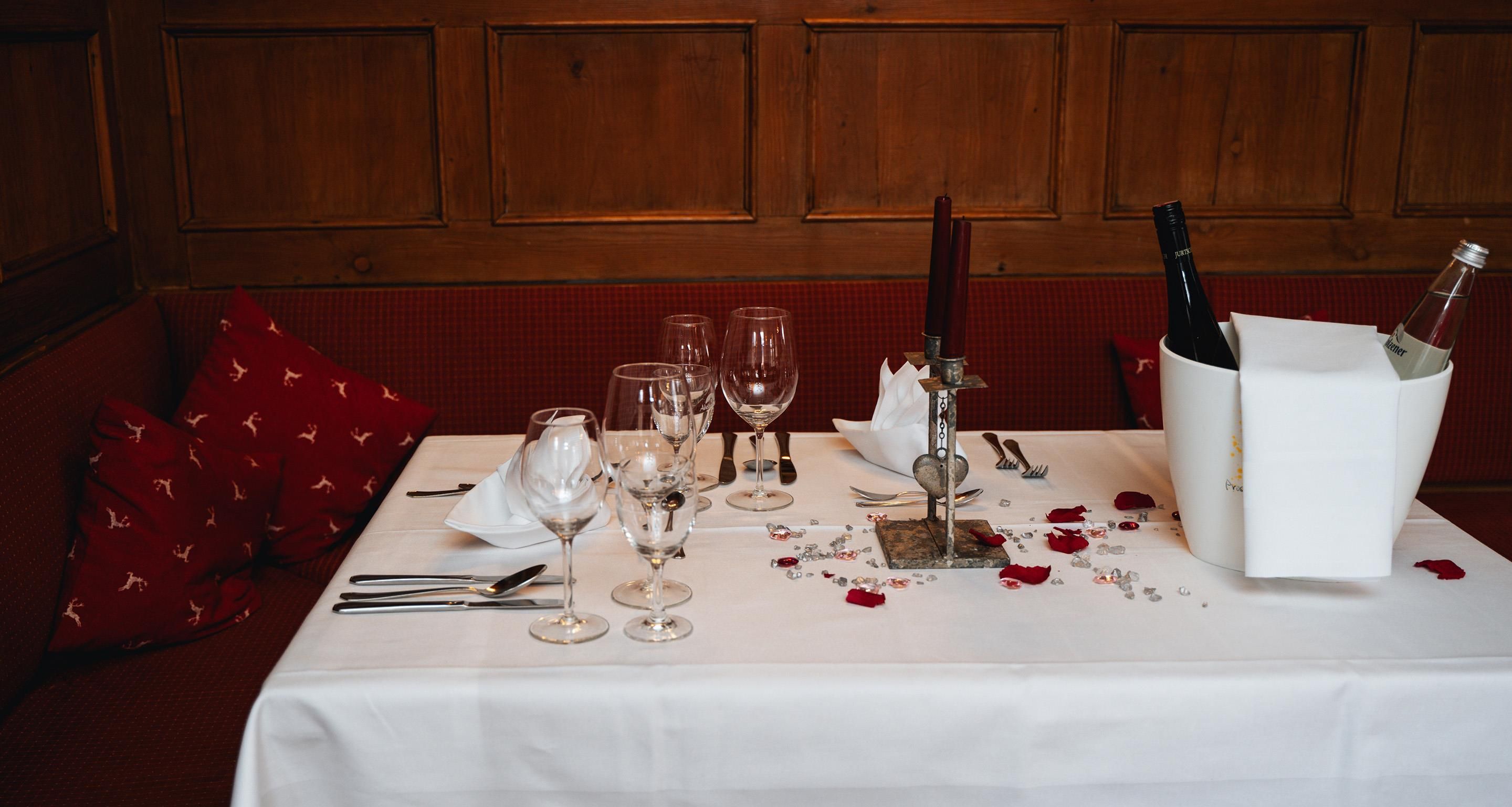 Une table mise pour un repas, avec des verres à vin, des couverts et un chandelier.