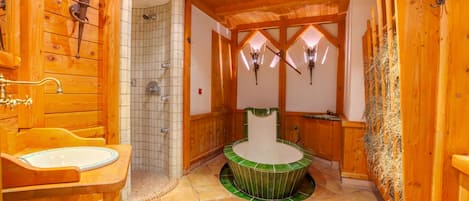 A wooden bathroom with a bathtub, a shower, and a sink.