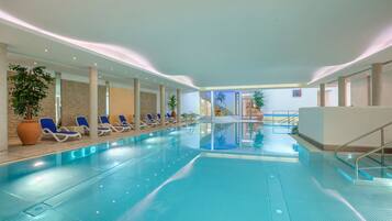 Una piscina cubierta, tumbonas