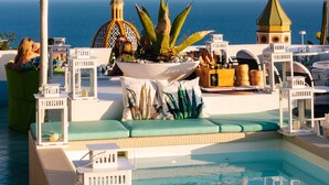 A pool area with lounge chairs, a small pool, and a view of the sea. - Hotel Le Fioriere (Praiano)