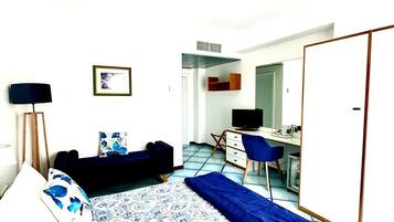 A bedroom with a bed, a desk, and a wardrobe.