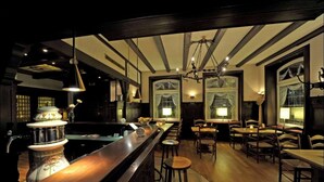A bar area with wooden flooring, bar stools, and pendant lighting. - Best Western Hotel Lippstadt (Lippstadt)