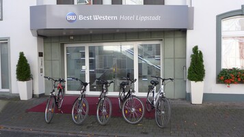 Entrada de un hotel con un cartel que dice "Best Western Hotel Lippstadt" y cuatro bicicletas estacionadas frente a él.