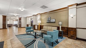 A hotel lobby with a seating area featuring a sofa and two armchairs, a coffee table, and a patterned rug. - Sleep Inn Boone University Area (Boone)