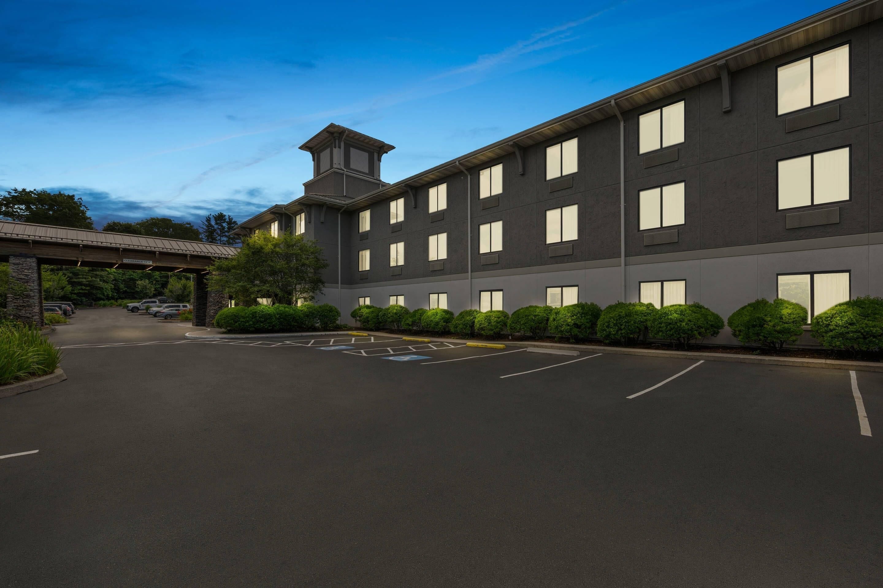 A modern building with a covered entrance, multiple parking spaces, and a well-maintained landscape.