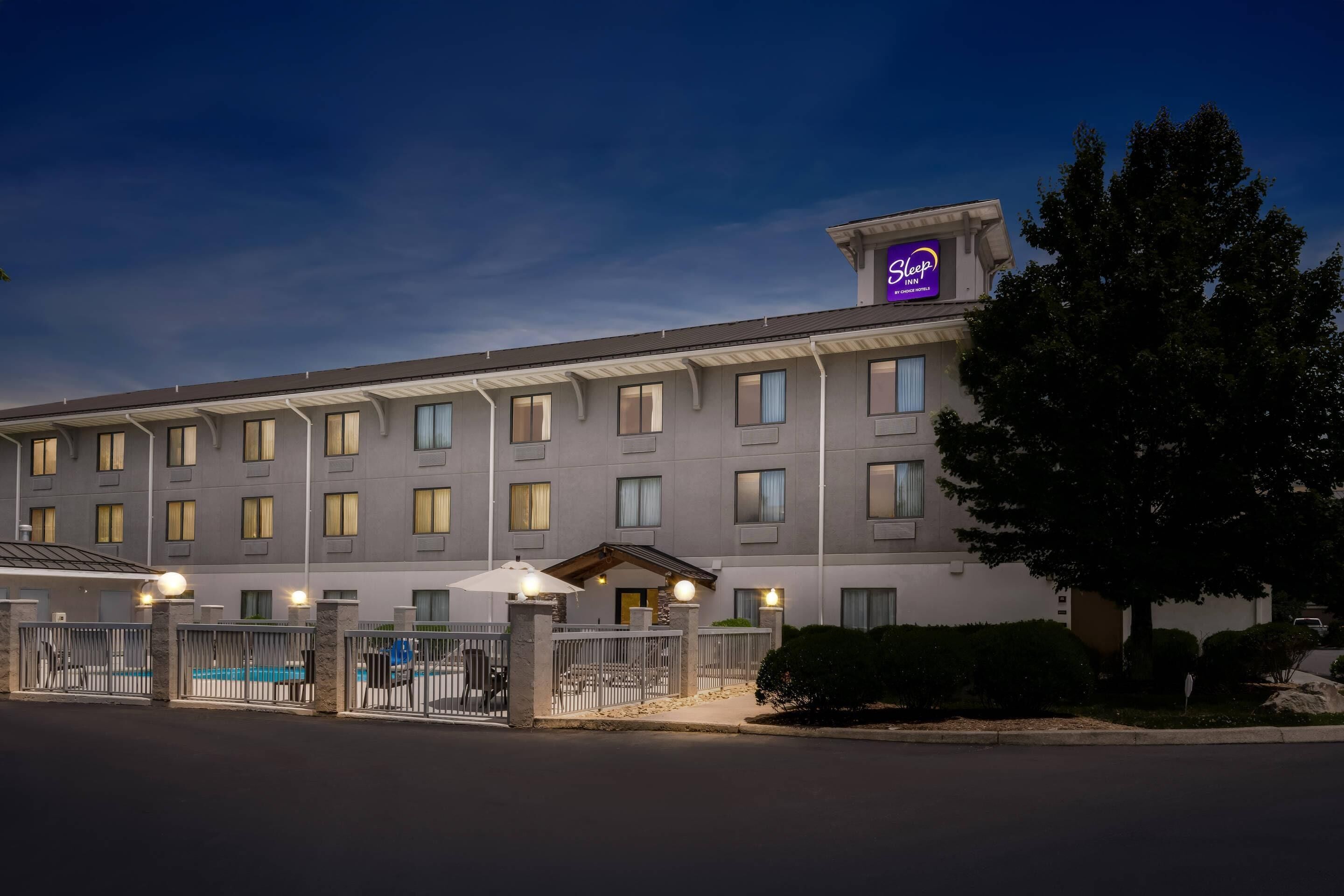 Un hôtel doté d’une piscine, de nombreuses fenêtres et d’une enseigne « Sleep Inn ».