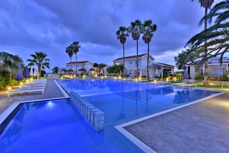 Una piscina al aire libre, sombrillas, tumbonas. Mon Repos Hotel