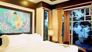 A hotel room with a large bed, a painting on the wall, a window with curtains, and a view of the outdoors. - Nisa Cabana Koh Chang (Ko Chang)