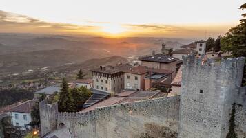 Un pueblo histórico con una imponente muralla de piedra y una estructura similar a un castillo.