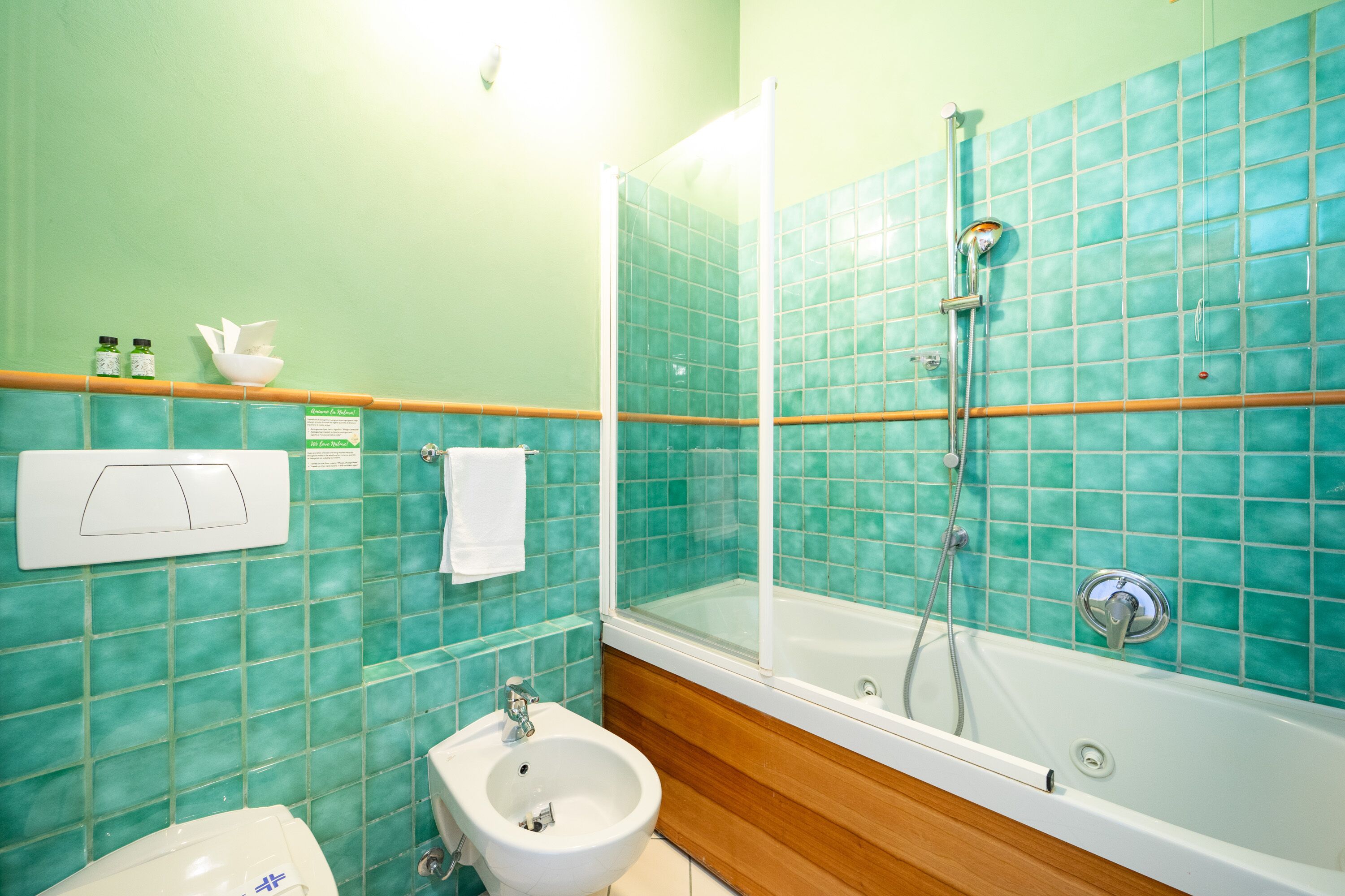 A bathroom with a glass-enclosed shower, a sink, and a toilet.