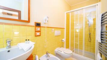 Une salle de bain équipée d’un lavabo, d’un bidet, de toilettes et d’une douche.