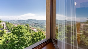 A room with a large window overlooking a mountainous landscape. - Hotel Cesare (San Marino)