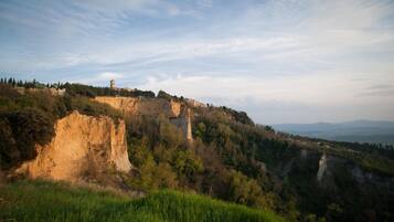 Un paisaje montañoso con un risco destacado y una torre pequeña en la cima.