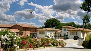 A residential area with houses, a parking lot, and a street lamp. - Hotel Foresteria Volterra (Volterra)