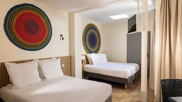 Une chambre d’hôtel avec un grand lit, un lit plus petit et un bureau.