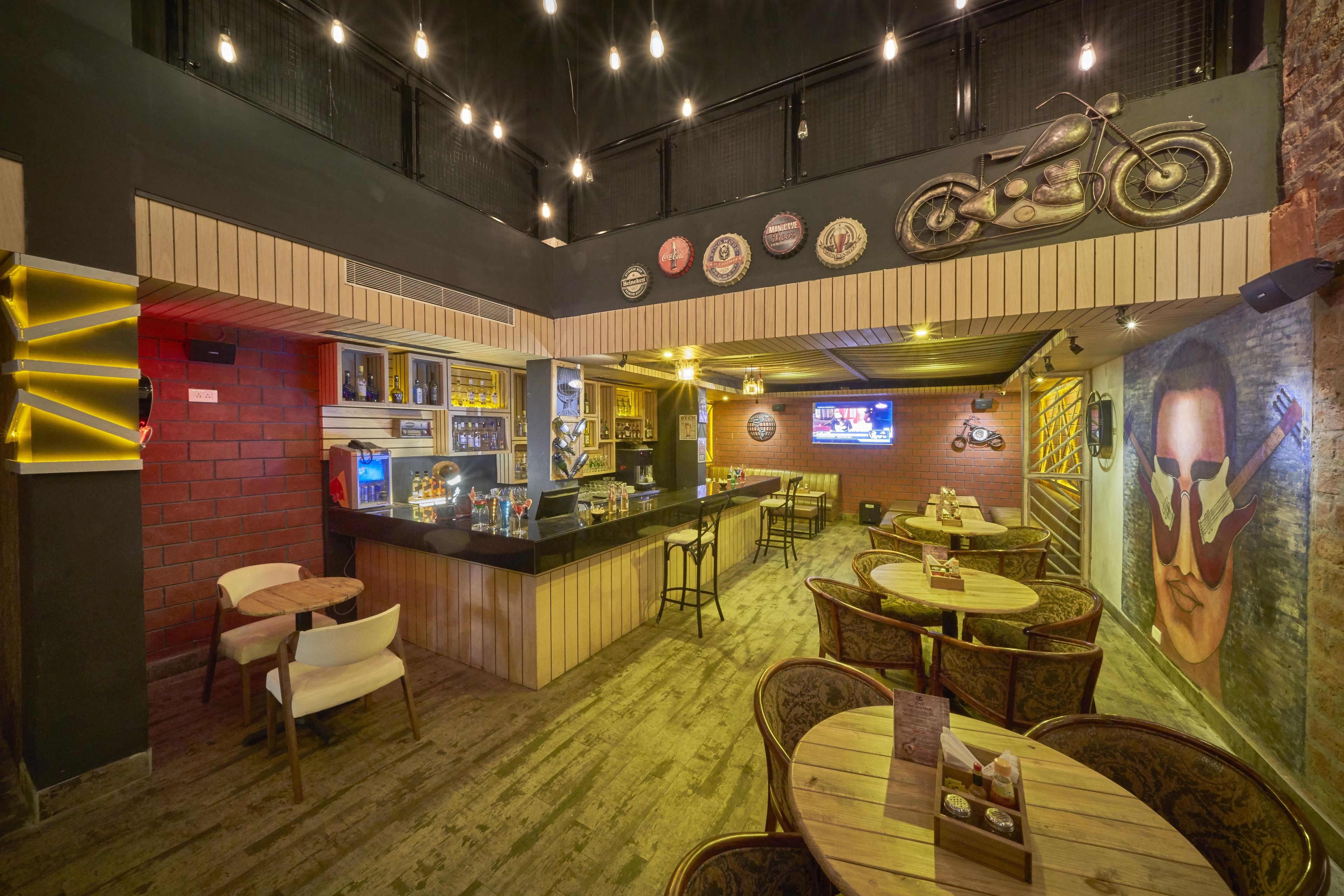 A bar area with a counter, stools, and a mural on the wall.