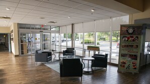 Un'ampia area interna con ingresso a vetri, diversi tavoli e sedie, e un espositore promozionale.