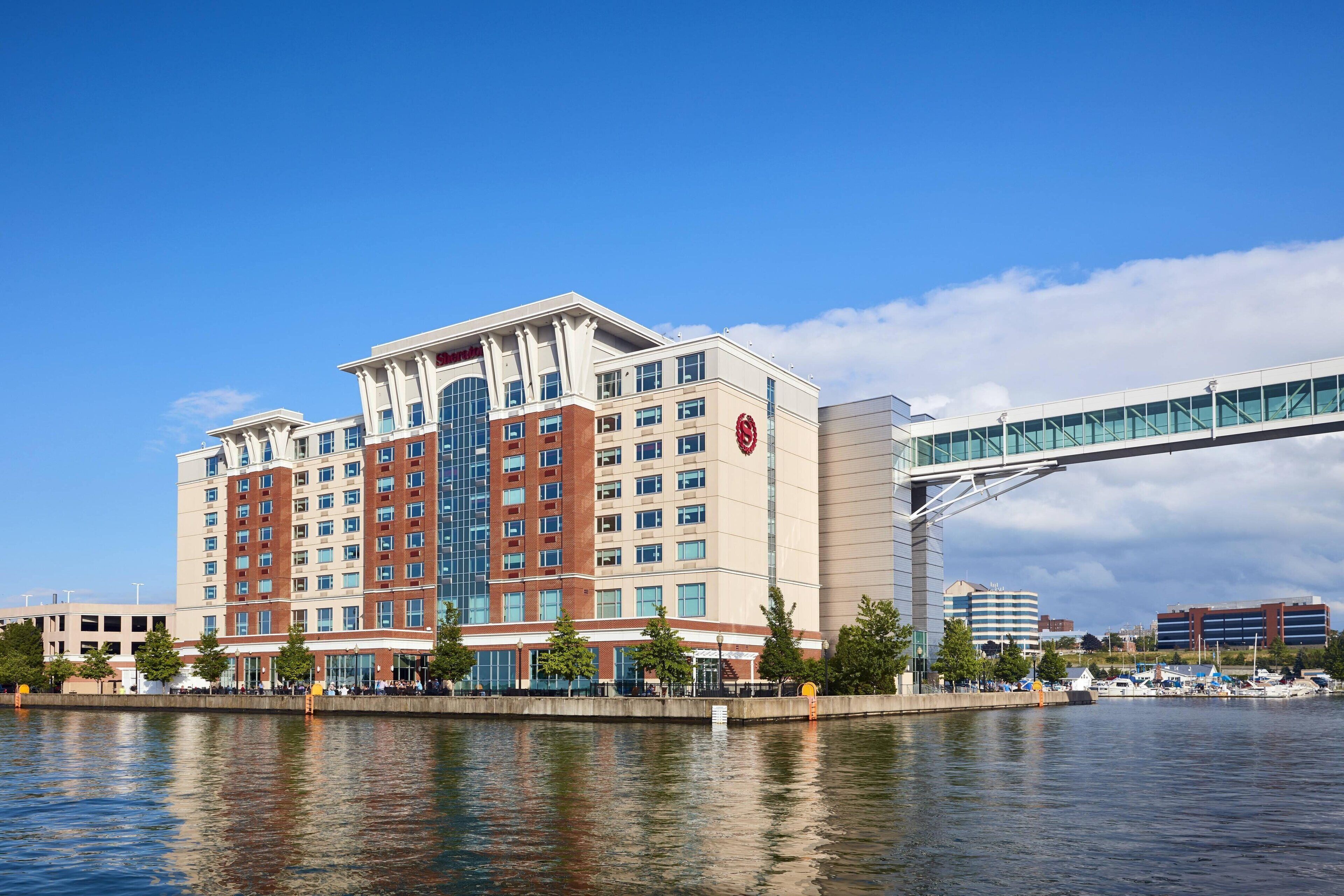 A hotel with multiple floors, a glass facade, and a waterfront view.