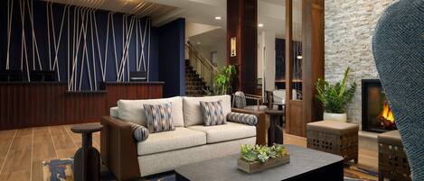 A modern living room with a sofa, coffee table, and a fireplace.