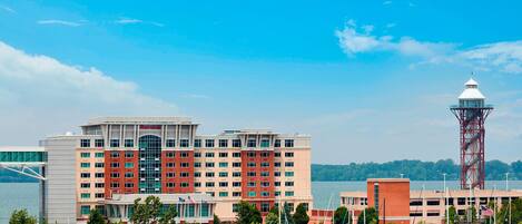A waterfront hotel with multiple floors, a prominent tower, and a marina with boats.