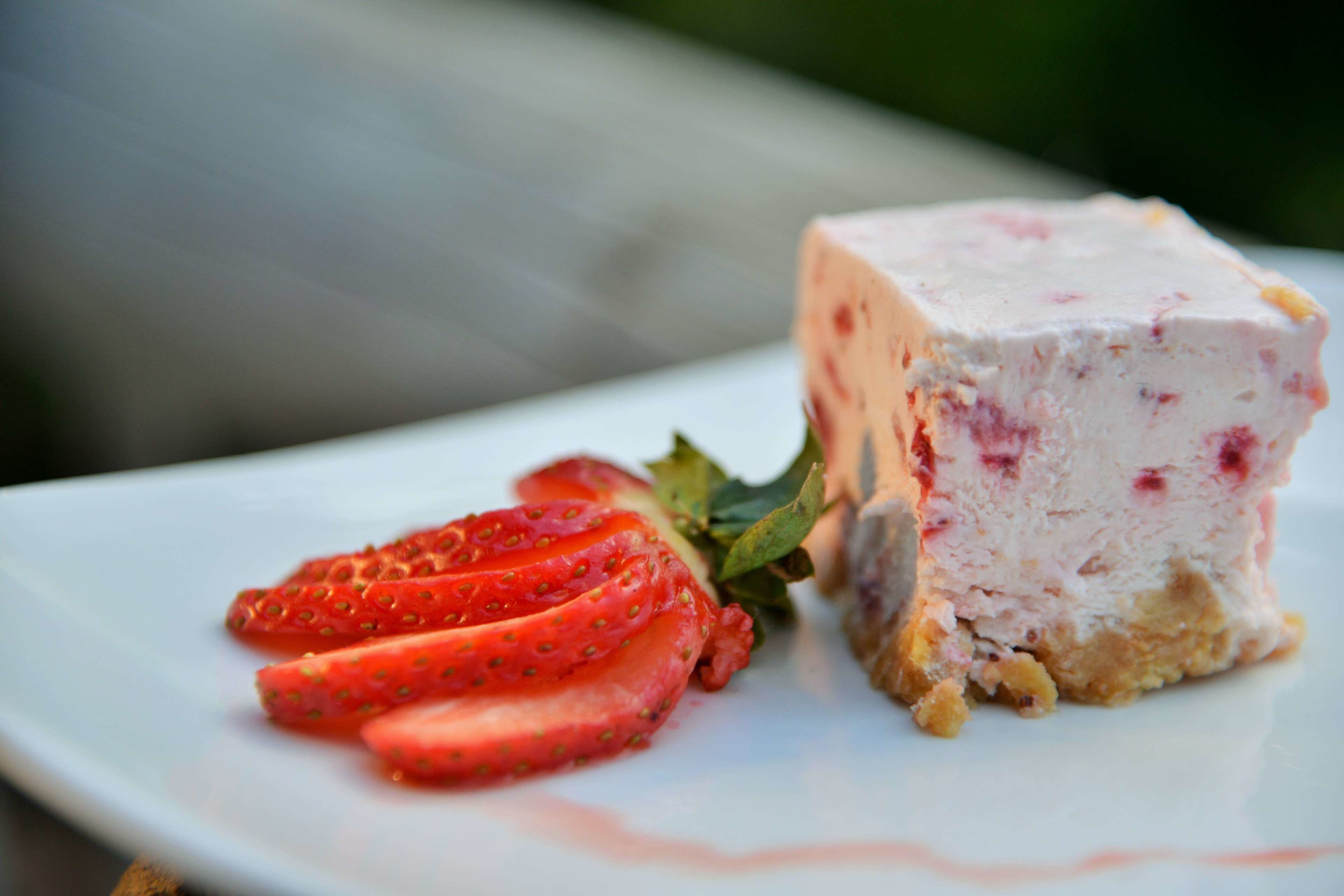 A dessert with strawberries and a creamy base on a white plate.