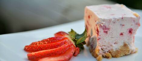 A dessert with strawberries and a creamy base on a white plate.