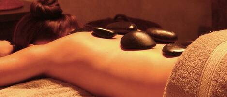 A person receiving a stone massage.