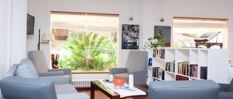 A modern living room with a sofa set, a coffee table, and a bookshelf.