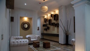 Un amplio salón con un espejo grande, dos sofás, una mesa de centro y una lámpara decorativa.