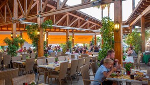 An outdoor dining area with wicker furniture and wooden beams. - Siesta Mar (Alayor)