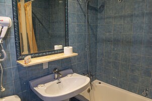 Un baño con lavamanos, espejo y ducha.