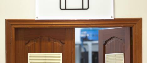 A wooden door with a vent and a sign above it.